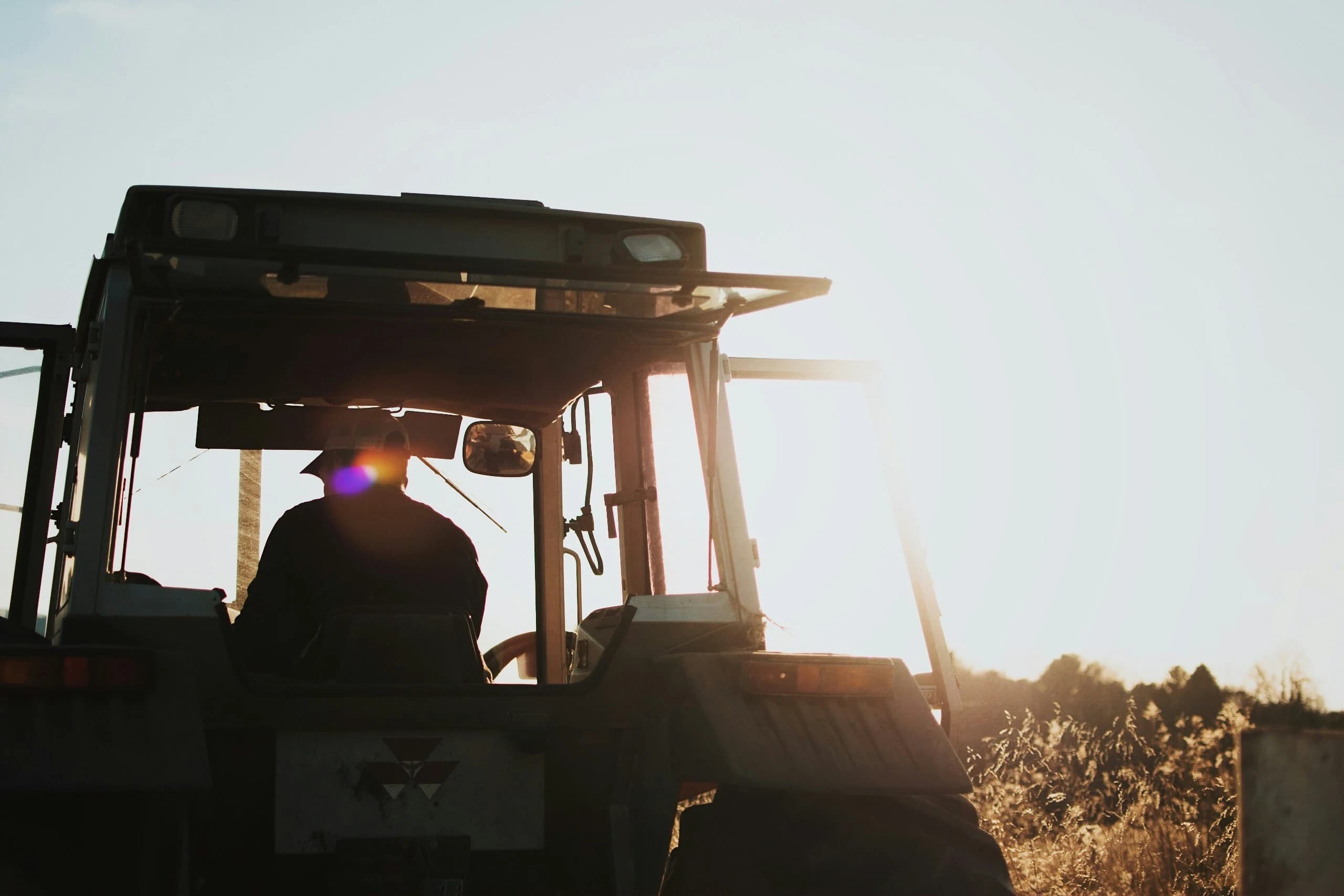 A farmer operating a tractor in a field.